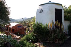 Two buildings at La Casita Verde: The composting toilet (right) and a house made from recycled bottles.